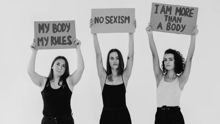 Frauen halten Schilder mit "My body my rules", "No sexism" und "I am more than a body"