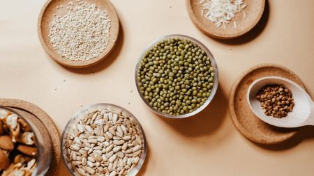 Schüsseln mit Quinoa, Reis, Sonnenblumenkernen und anderen Lebensmitteiln